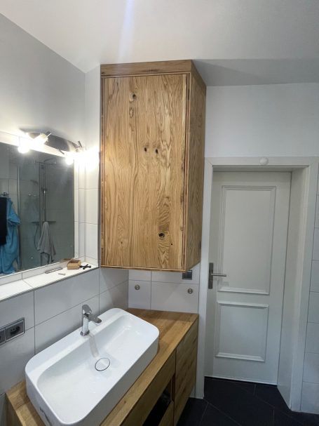 Holzschrank über einem Waschbecken in einem modernen Badezimmer.